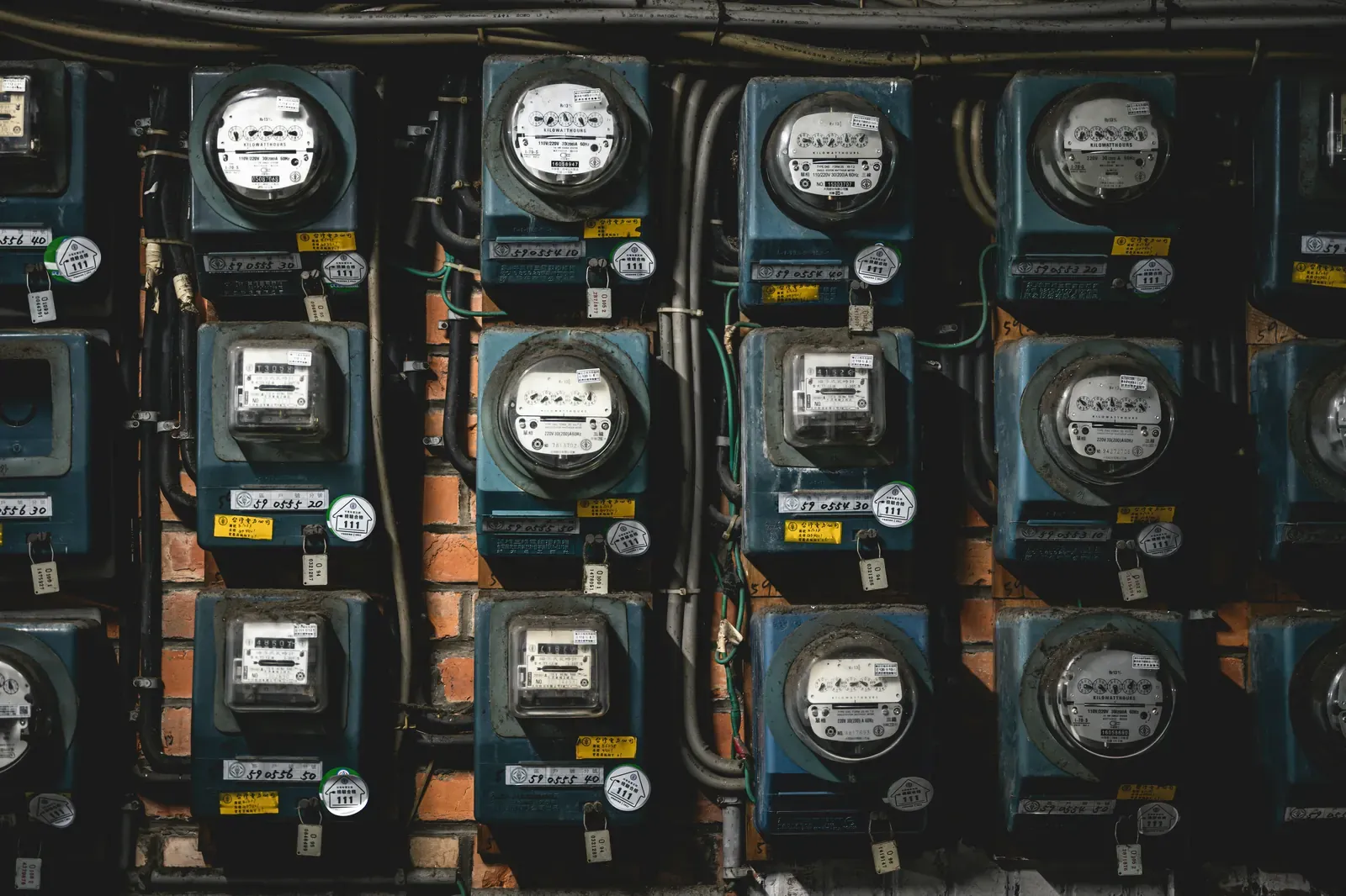 A bank of round electric utility meters on a building wall